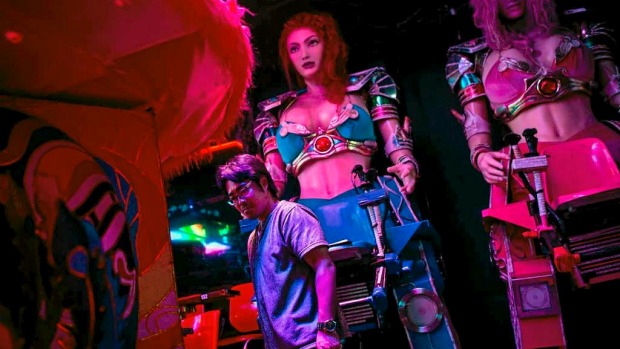A staff member works to prepare two large female robots prior to the start of a show at The Robot Restaurant in Tokyo, Japan.