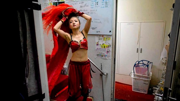 A performer puts on her costume backstage prior to the start of a show at The Robot Restaurant in Tokyo, Japan.