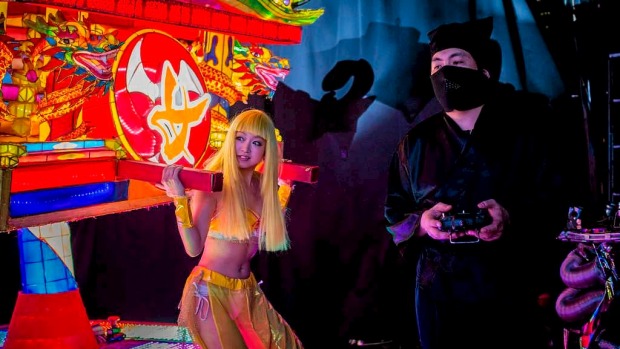 Dining out: A stage hand dressed as a ninja controls a vehicle by remote control during a show at The Robot Restaurant ...