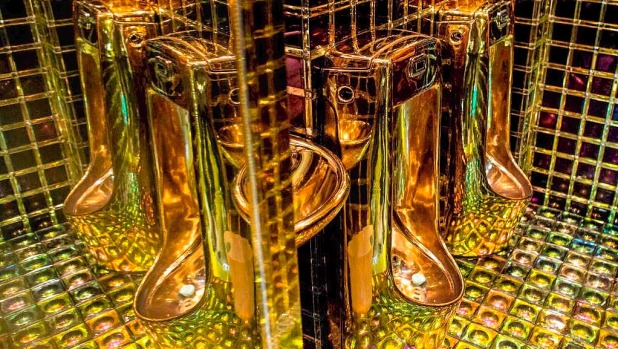 Gold coloured urinals are seen in the mens bathroom  at The Robot Restaurant in Tokyo, Japan.