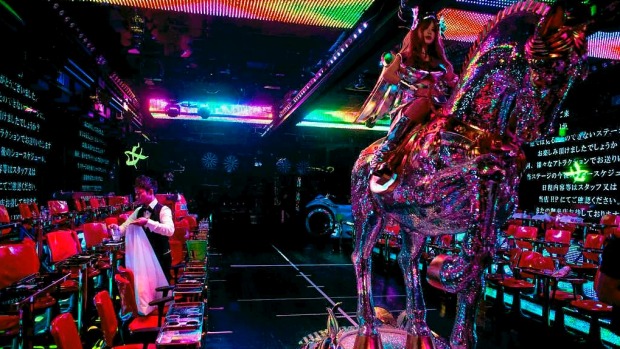 A man cleans up the stage after a show as a large robotic horse is moved back into position after a show at The Robot ...