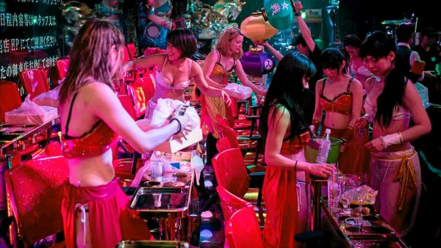 Dancers and performers work to clear garbage in between shows at The Robot Restaurant in Tokyo, Japan.