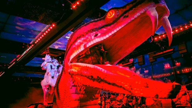 A dancer rides a large robotic snake during a show at The Robot Restaurant in Tokyo, Japan.