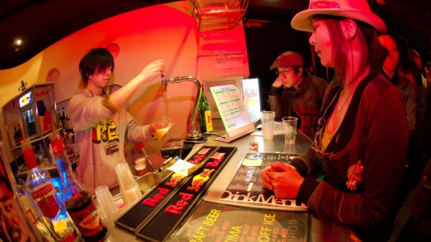 A barman pours beer at a bar, in Shibuya, Tokyo.