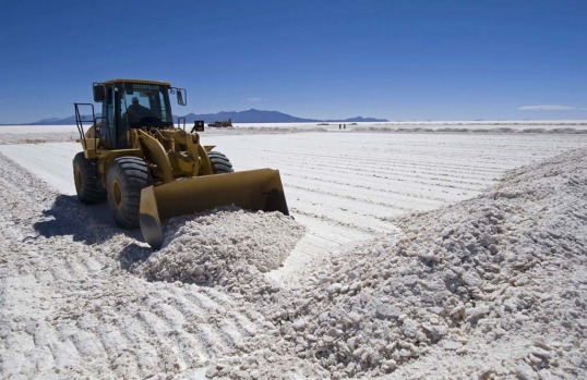 An excavator piles up salt at the Uyini Salt Flats in Bolivia.