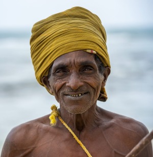 A stilt fisherman wearing a traditional Sri Lankan headdress.