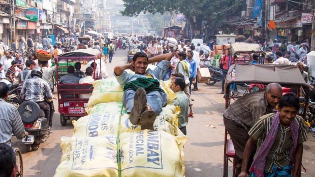 A porter rests on sacks of spices in the spice market in Old Delhi.