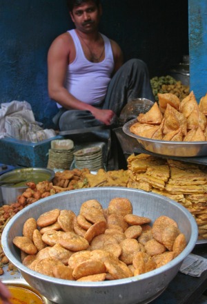 A samosa vendor sells his tasty treats in back alley near a busy Delhi market.