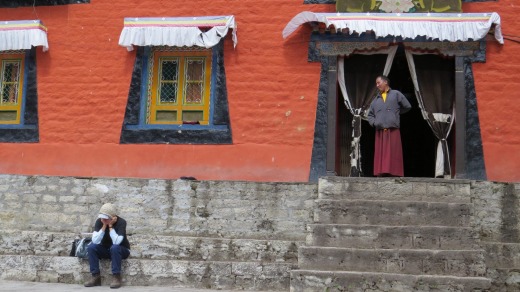 A monk looks at a trekker at Thame monastery.