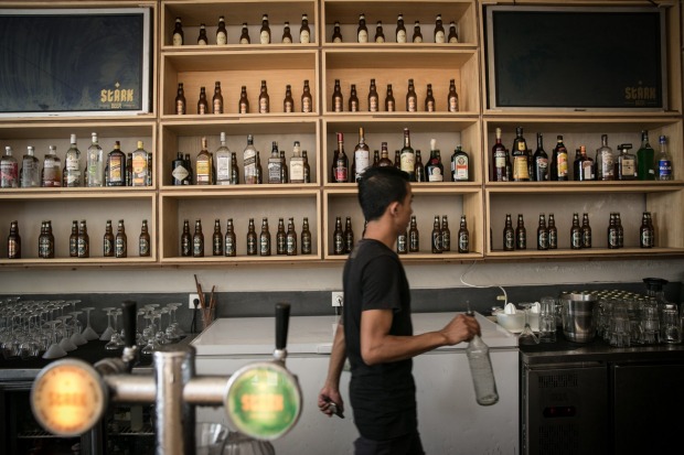A bartender walks as he prepares a drink in Stark beer house on Legian Street in Kuta, Bali, Indonesia.