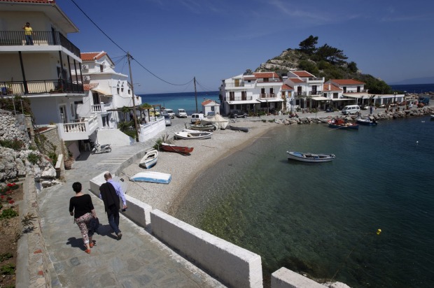 Travellers explore the village of Kokkari, on Samos Island, Greece.