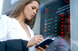 woman writing in notepad near currency exchange place