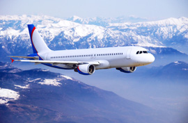 airplane in flight flying blue sky mountains snow