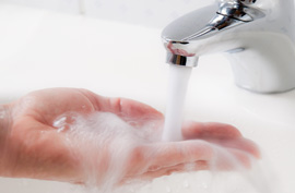 the palm of someone's hand being held under a stream of water in a bathroom sink