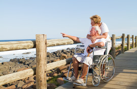 disabled traveler wheelchair couple senior water boardwalk beach sea