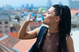 woman drinking water from a plastic water bottle