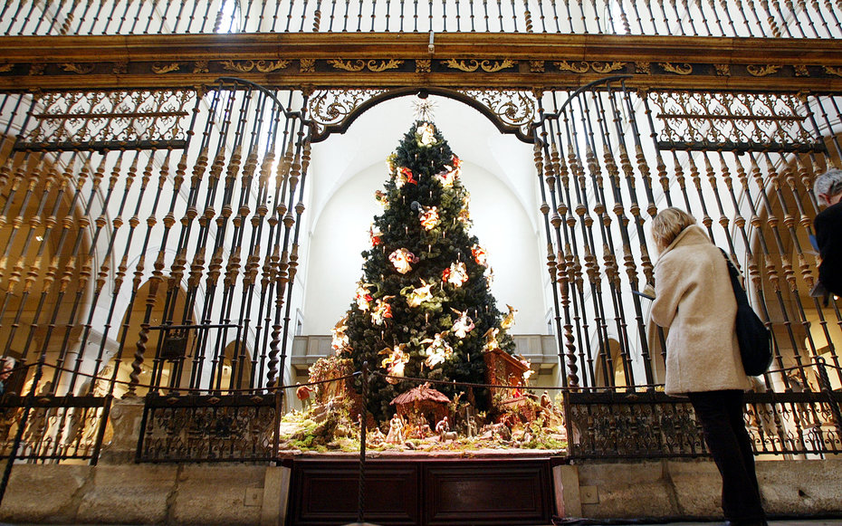 NEW YORK - DECEMBER 2:  A woman stands in front of the annual Christmas tree on display in the Metropolitan Museum of Art December 2, 2002 in New York City. The 20-foot blue spruce is adorned with 50 suspended angels and is on display in the museum's Medi